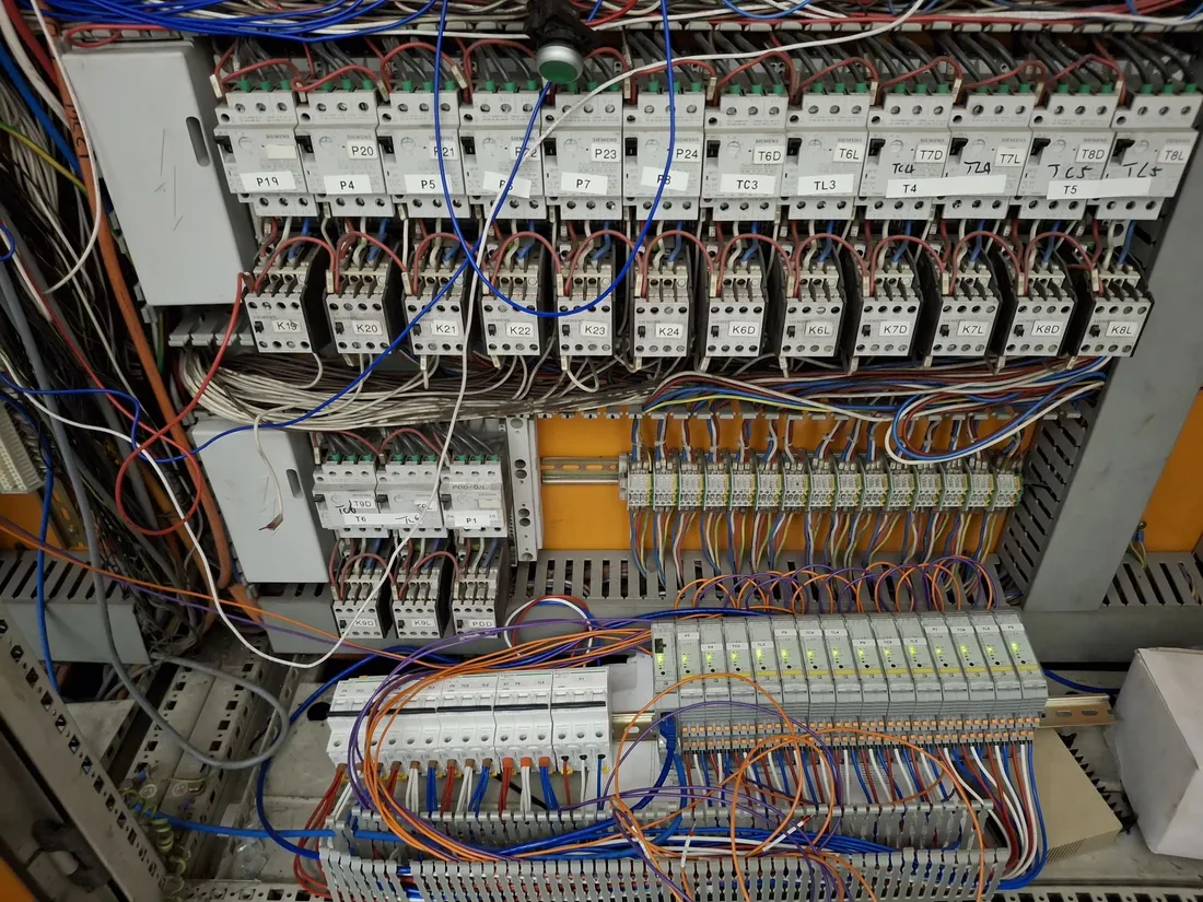 Contactor control board mid-retrofit with original motor contactors above and new slim interface relays and terminals fitted below