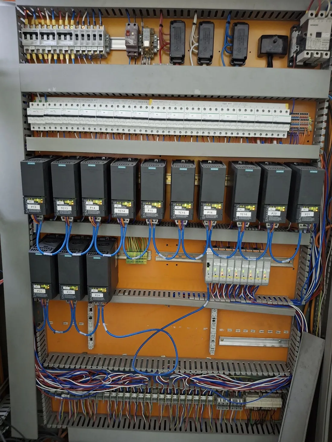 Finished retrofit board with rows of Siemens G120C drives on PROFINET replacing the old contactor banks in the same enclosure