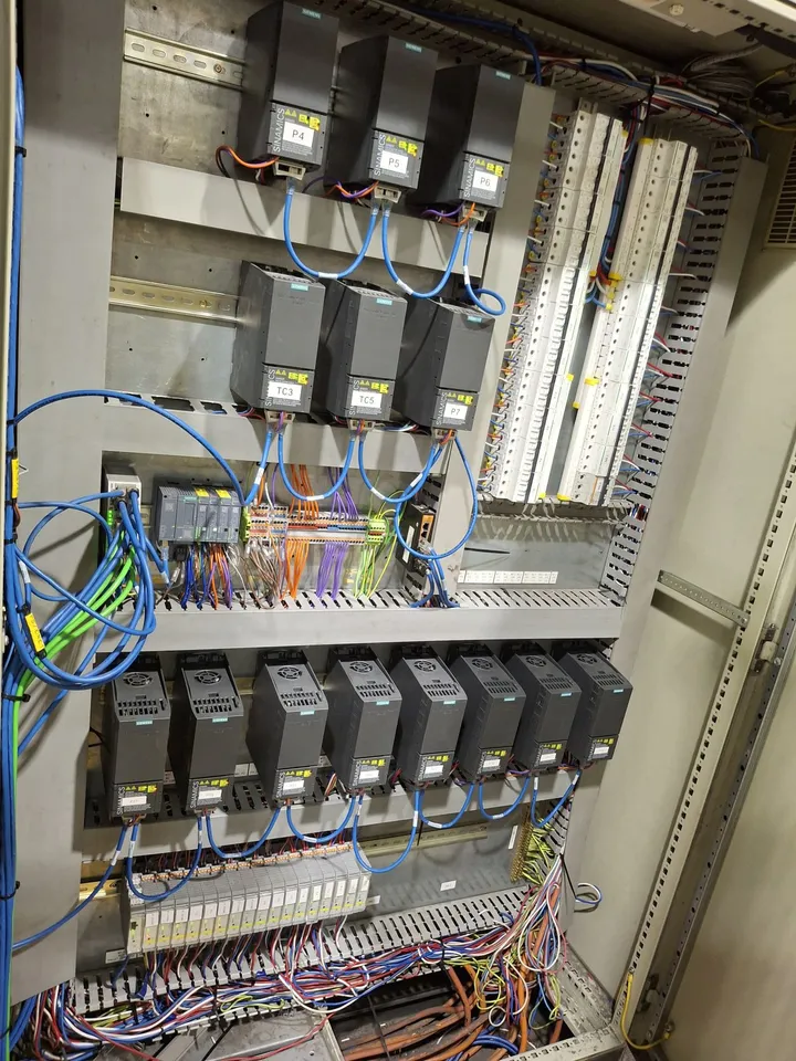 Upgraded drive board with rows of Siemens G120C drives and distributed I/O connected by tidy PROFINET patch cables